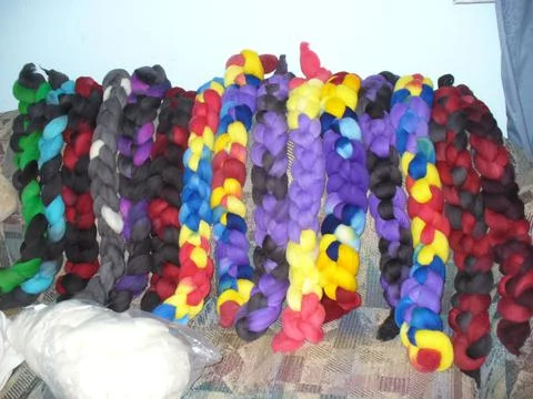 Intensely colored hand dyed wool roving tossed on couch for spinning Stock Photos