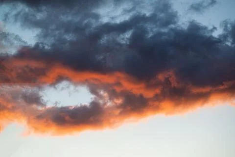 Intensely colored puffy clouds at sunset with yellows blue and pinks set agai Fotos de archivo