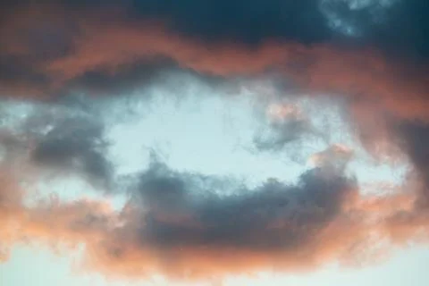Intensely colored puffy clouds at sunset with yellows blue and pinks set agai Fotos de archivo