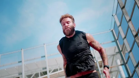 Intensive exercising guy doing feet jumps and push-ups leaning on sport ground Stock Footage 117130644