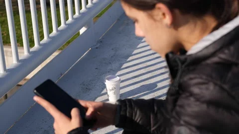Intentionally out-of-focus side shot of a teenage girl using her smartphone Stock Footage 167369402