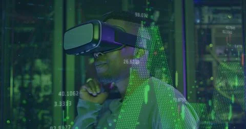 Interacting man wearing VR headset exploring green data charts at tech lab near Stock Photos