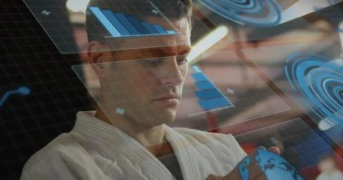 Interacting man wearing white gi at control room, moving holographic globe wi Stock Photos