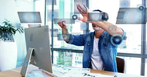 Interacting middle-aged man wearing denim shirt and VR headset using holograms Stock Photos