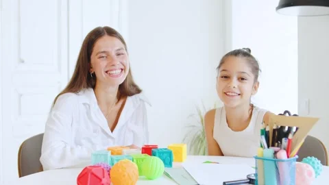 Interaction between a speech therapist and a young girl during a playful Stock Footage 315552184
