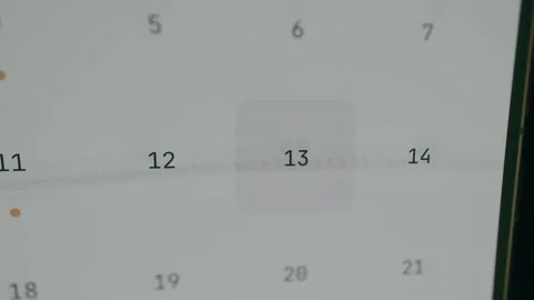 Interactive calendar screen with a finger choosing the 13th date Stock Footage 333860230