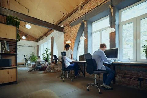 Interactive co-working space. Bustling co-working environment with young Stock Photos