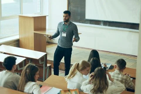Interactive Learning Session. Young teacher leading lecture in front of Stock Photos