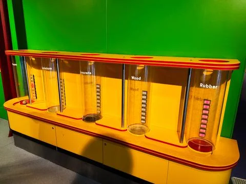 Interactive material density display with labeled cylinders at a colorful s.. Stock Photos