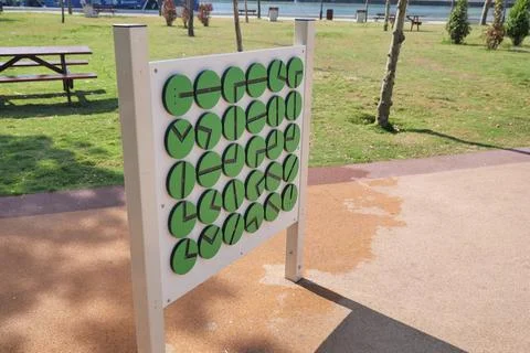 Interactive Playground Panel with Rotating Green Discs for Educational Play Stock Photos