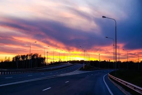 Interchange of the highway. Dramatic sky, fiery sunset. Stock Photos