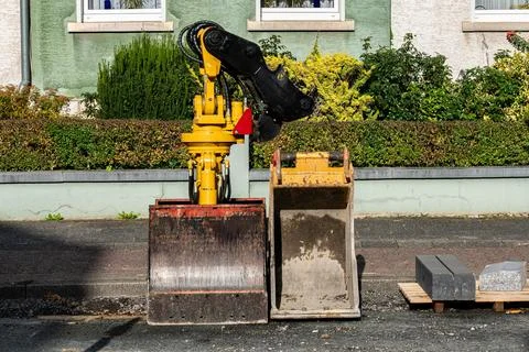 Interchangeable excavator buckets at a construction site. Stock Photos