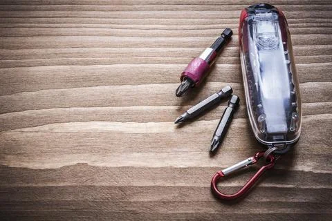 Interchangeable metal screwdriver heads in container on wooden plate Copying Stock Photos