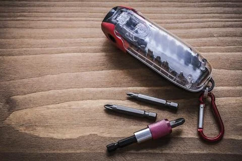 Interchangeable screwdriver heads in container on wooden plate horizontal design Stock Photos