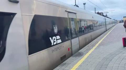 The intercity train pulls up to the station platform. The cars are slowly moving Stock Footage 256896024