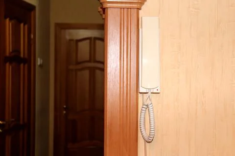 The intercom handset hangs on the wall in the hallway Stock Photos