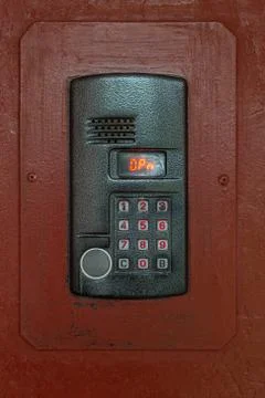 An intercom on old painted brown steel surface with a keypad, digital display Stock Photos
