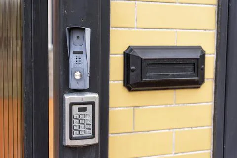 Intercom panel with a video camera on the brick fence of private house Stock Photos