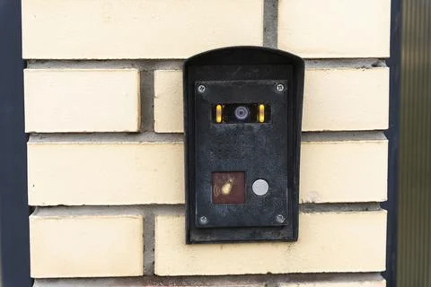 Intercom panel with a video camera on the brick fence of private house Stock Photos