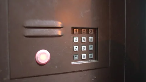 Intercom system issues call signal with electronic ringing in a building lobby Stock Footage 330638306