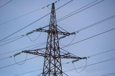Interconnected Web of Electrical Towers Against a Sunset Sky Stock Photos