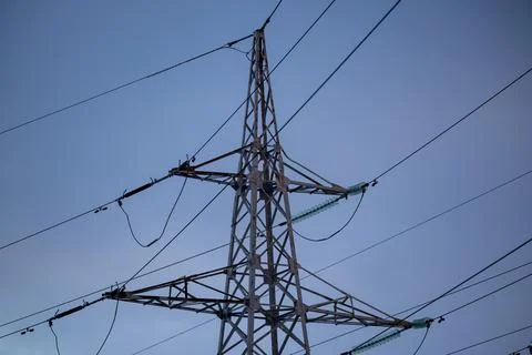 Interconnected Web of Electrical Towers Against a Sunset Sky Foto stock