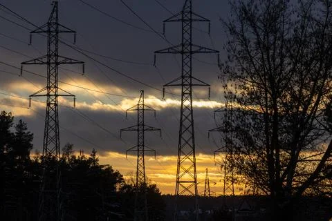 Interconnected Web of Electrical Towers Against a Sunset Sky Stock Photos