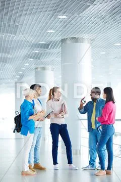 Intercultural students discussing lecture at break Stock Photos