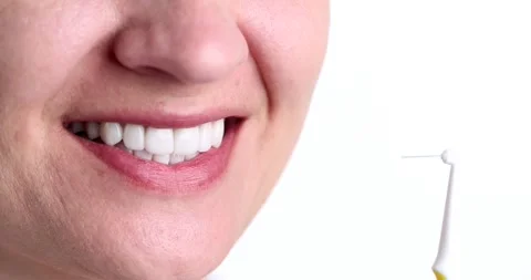 Interdental brush for cleaning between teeth near beautiful snow white female Stock-Footage 241902205