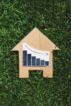 Interest rates going down, graph showing stats decreasing over house icon o.. Stock Photos