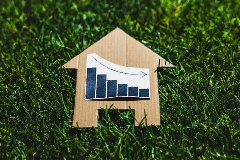 Interest rates going down, graph showing stats decreasing over house icon o.. Stock Photos