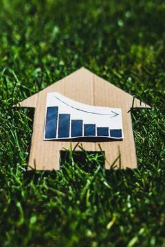 Interest rates going down, graph showing stats decreasing over house icon o.. Stock Photos