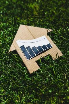 Interest rates going down, graph showing stats decreasing over house icon o.. Stock Photos