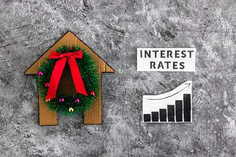 Interest Rates text and graph with stats going up next to cardboard house w.. Stock Photos