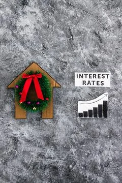 Interest Rates text and graph with stats going up next to cardboard house w.. Stock Photos