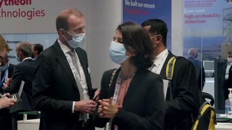 Interested customer asking questions at kiosk, busy conference, masks, Stock Footage 170779807