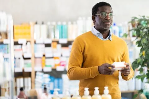 Interested customer browsing box of prescribed pills in pharmacy Stock Photos