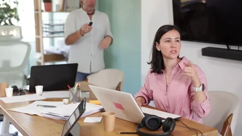 Interested middle-aged male and female colleagues watching project presentation Stock Footage 341785433