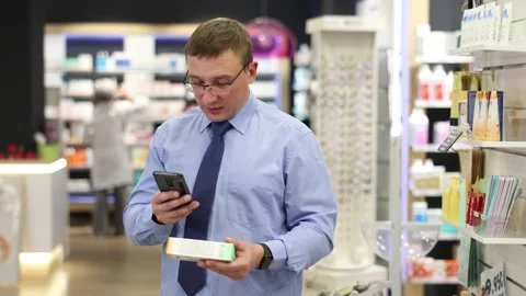Interested middle-aged male client scanning QR of medical product held in hand Stock Footage 275003724