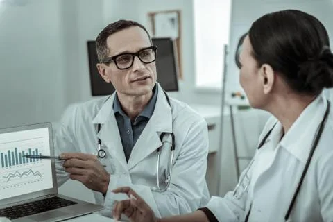 Interested researcher explaining data to his female workmate 스톡 사진