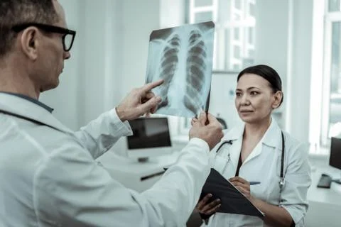 Interested traumatologist pointing on the x-ray photo Stock Photos