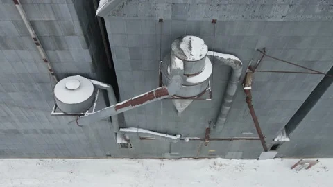 Interesting ascending side view of old, rusty grain elevator on cold winter day. 库存影片 157768720