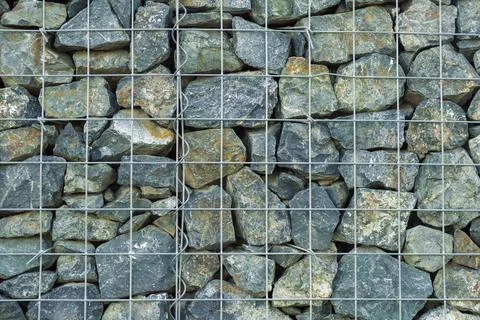 Interesting creative background of gray granite medium-sized stones behind a Stock Photos