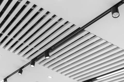 Interesting white lath ceiling with modular light fixtures Fotos Stock