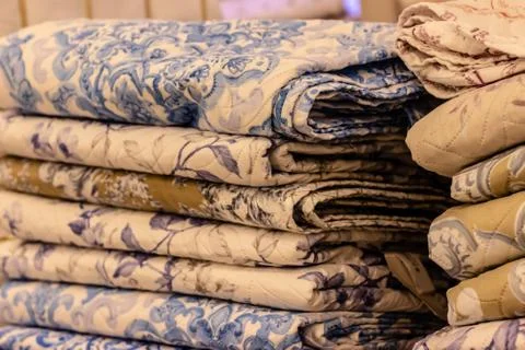 Interesting yellow and blue patterned bedsheet pile Foto stock