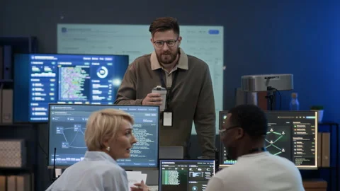 Interethnic Cybersecurity Specialists Talking in Control Room during Break Stock Footage 334935538