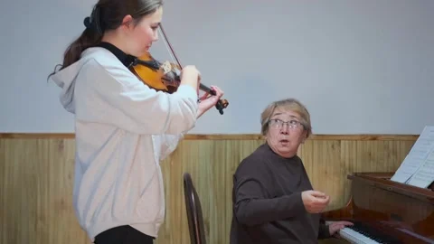 Intergenerational music lesson with violin and piano performance Stock Footage 314155223