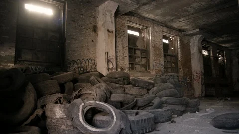 Interior abandoned brick building pile of old tires in foreground Stock Footage 89944897