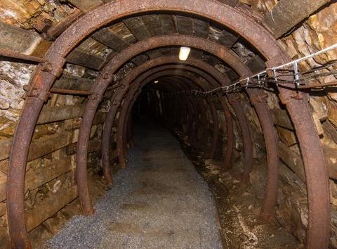 Interior of abandoned old coal mine. Dangerous tunnels full of dirt and rusty Stock Photos