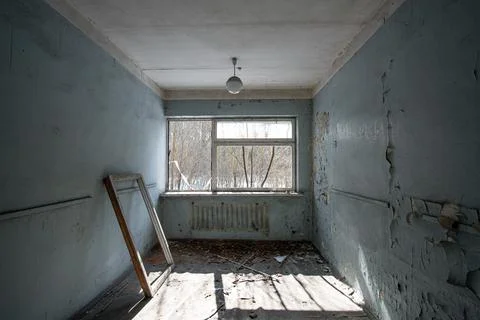 Interior of an abandoned room with a broken window frame and peeling walls pa Stock Photos